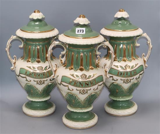 A set of three Victorian style green and gilt lidded ceramic drug vases, with painted labels height 39cm